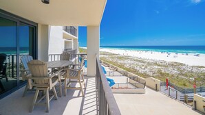 A balcony with a view of a beach and ocean.