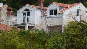 A residential building with a balcony, a chimney, and a tiled roof. - Villa Fede (Zupa dubrovacka)