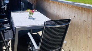 An outdoor dining area with a table and chairs, a view of mountains, and a wooden fence. - Rosenhaus in Schwarzenberg (Schwarzenberg)