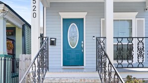 A house with a blue door, a number 520 sign, and a decorative metal railing. - Modern 4BR Mid-City home with heated pool & parking. Steps to streetcar, near FQ & parades. (New Orleans)