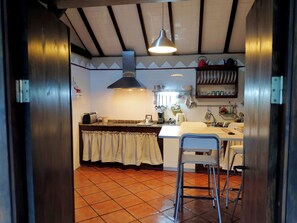 A kitchen with a central island, a hanging light fixture, and a tiled backsplash.