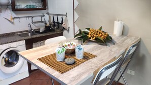 Eine Küche mit Waschmaschine, Spüle und Essbereich mit Stühlen und Tisch.