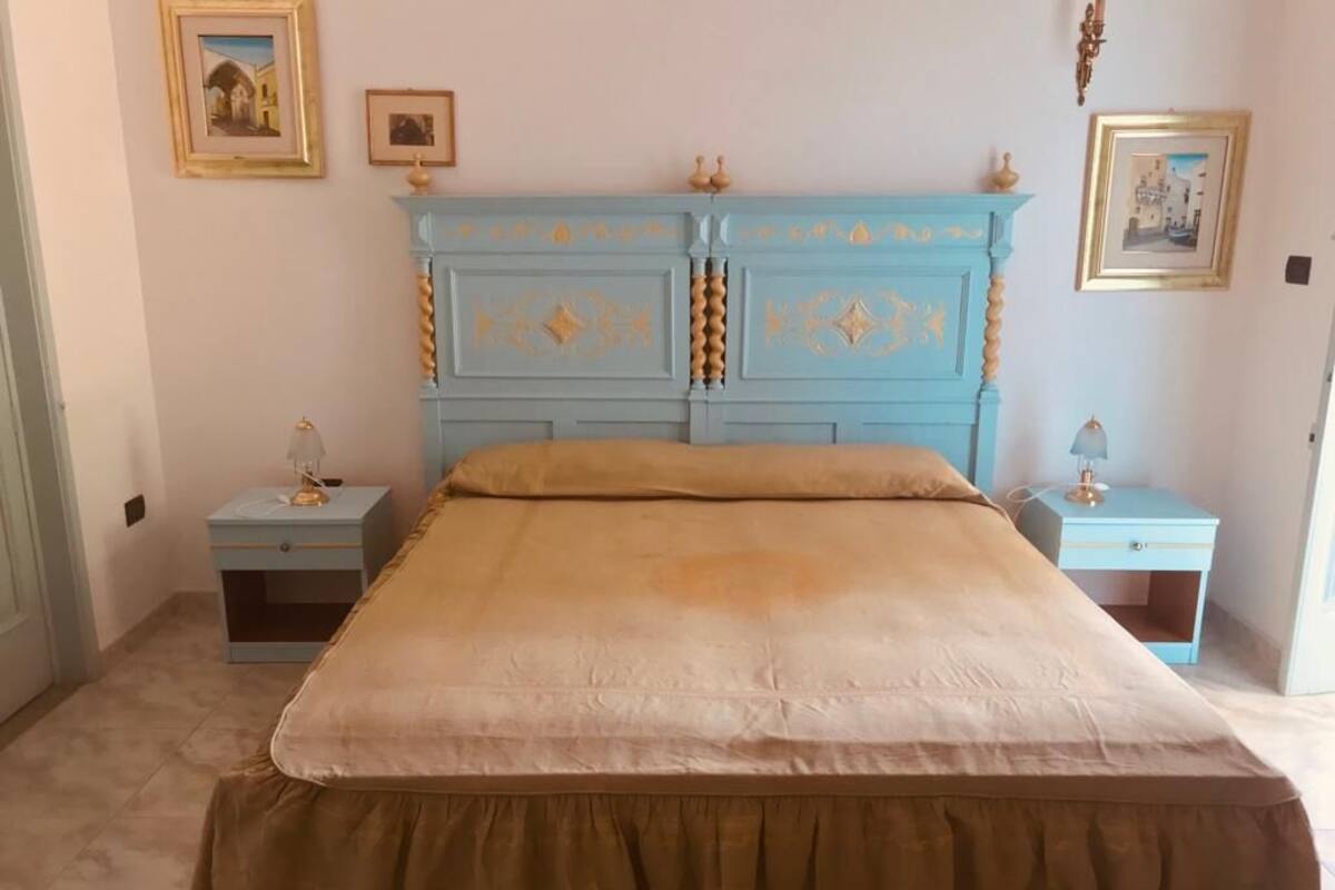 A bedroom with a bed, two bedside tables, and a nightstand.