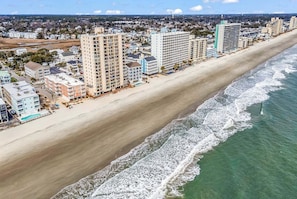 A coastal cityscape with high-rise buildings, a sandy beach, and a clear view of the ocean. - Duneside I 104 - Oceanfront Complex (Oceanview Unit) in Garden City Beach (Garden City)