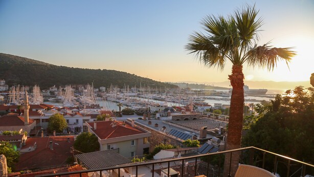 A balcony with a view of a marina and buildings. - Villa Veria (Cesme)