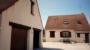 Un edifici amb un gran portal de garatge i un teulat d'uralita.