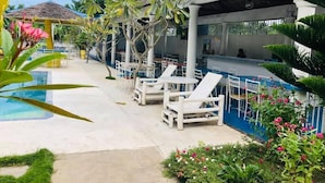 A poolside area with lounge chairs, a bar, and a covered seating area. - Sweet Water Resort (Zamboanguita)