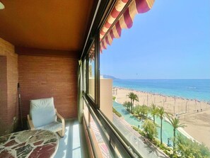 A balcony with a view of a beach, a pool, and a clear sky. - SEAFRONT PONIENTE BEACH BENIDORM R049 (Benidorm)