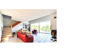 A spacious living area with a staircase, a red sofa, and a fireplace. - 100% Happiness superb villa with sea view near beach, idyllic setting (Conca)
