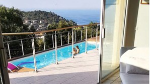Un balcón con piscina con vistas a la costa.