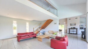 A spacious living area with a staircase leading to an upper floor, a dining area, and a kitchen. - 100% Happiness superb villa with sea view near beach, idyllic setting (Conca)