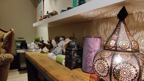 A wooden table with decorative items, a hanging lantern, and shelves with various objects. - A farm in a stunning nature. Peace and quiet. Out of tourist traffic. (Dalabyggð)
