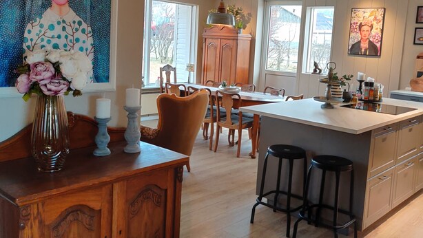 A modern kitchen with a large island, wooden cabinetry, and a dining area with chairs and a table. - A farm in a stunning nature. Peace and quiet. Out of tourist traffic. (Dalabyggð)