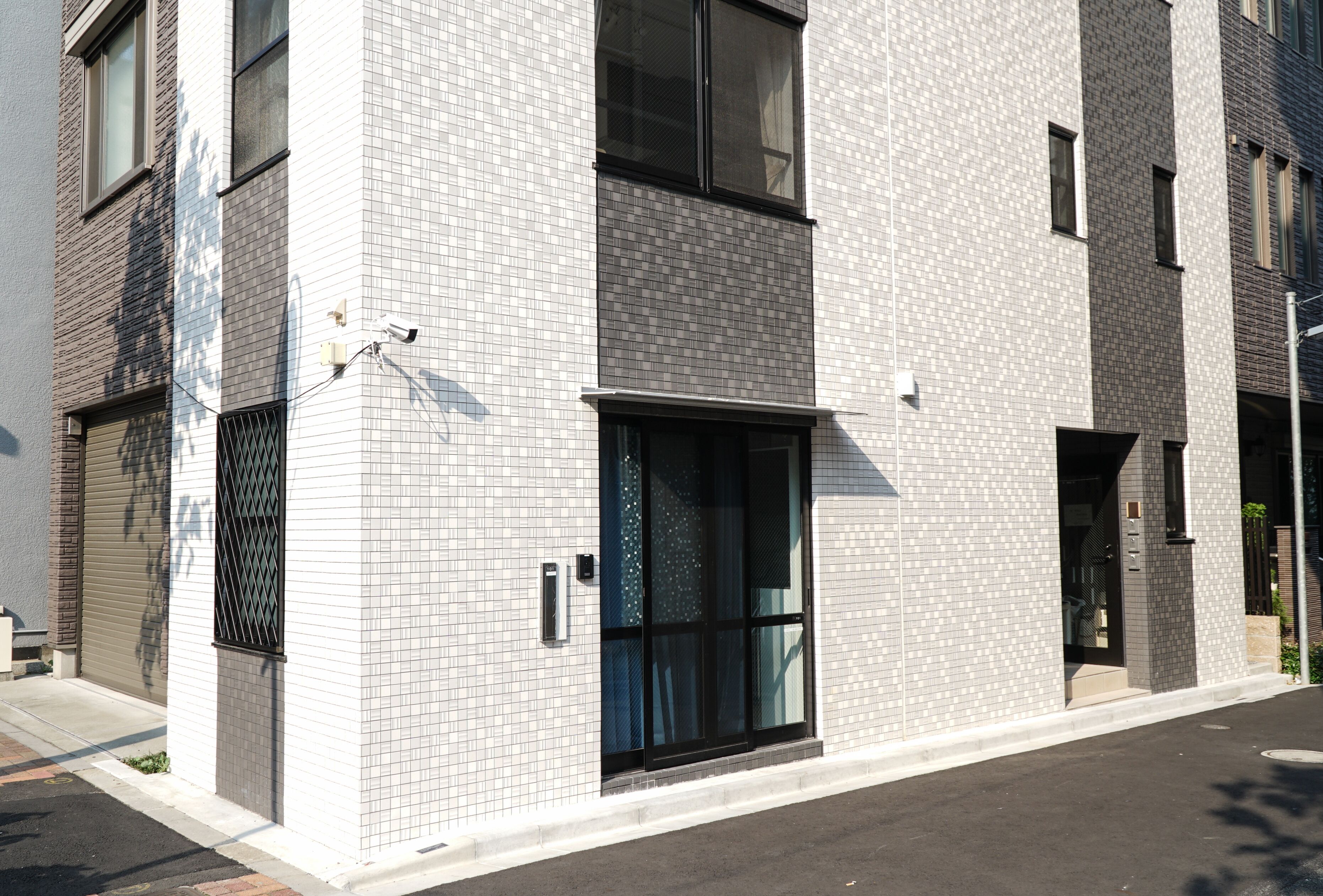 A modern building with a tiled facade, large windows, and a visible entrance.
