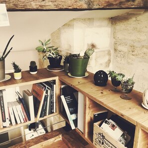 A wooden desk with various potted plants, a small globe, and books.