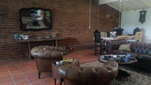 A living room with a brick wall, a mirror, a sofa, a coffee table, and a fireplace.