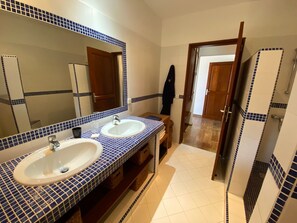 A bathroom with two sinks, a large mirror, and a wooden vanity.