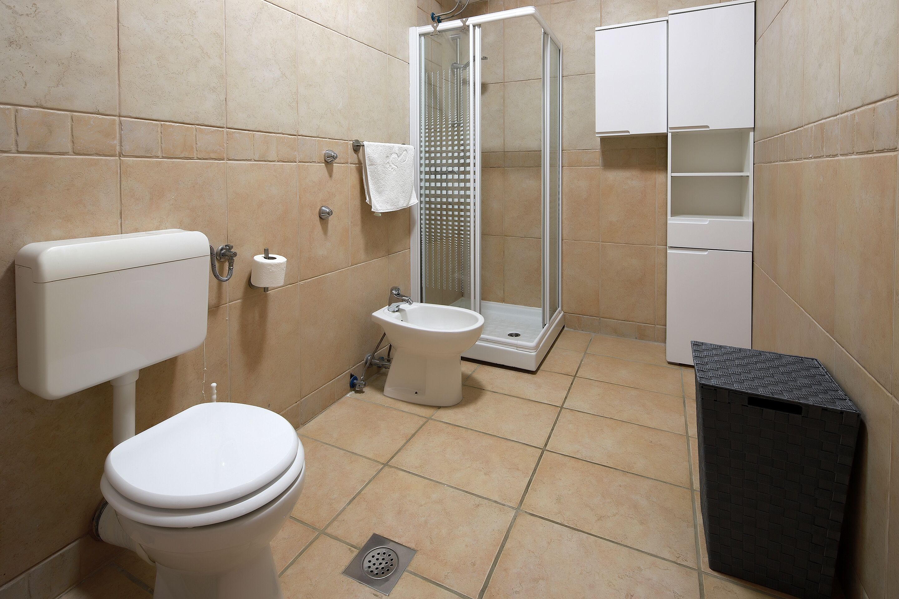 Une salle de bain comprenant des toilettes, un bidet et une douche.