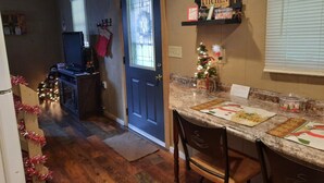 Une cuisine avec une porte en bois, un petit sapin de Noël et des décorations de fêtes.