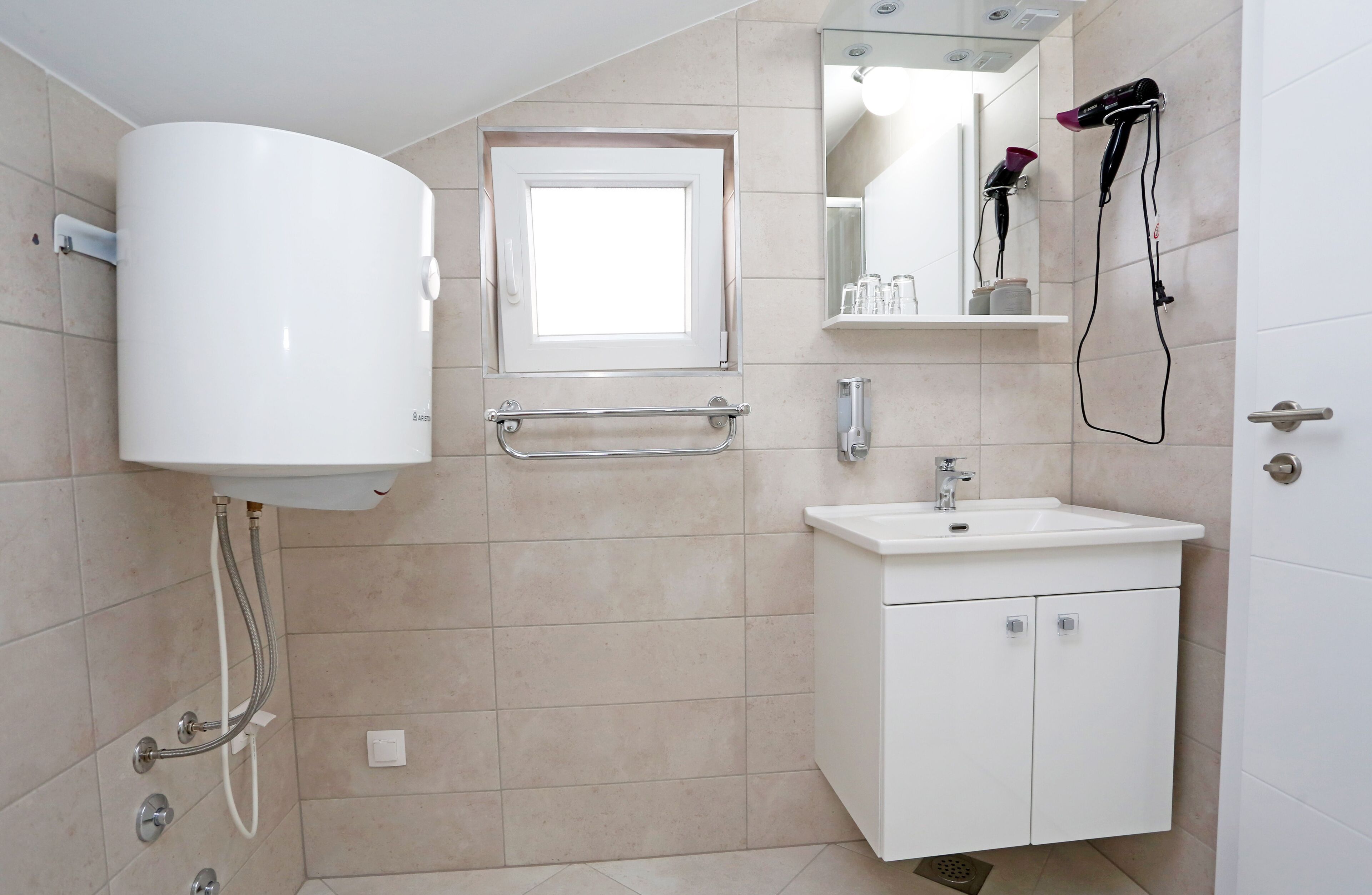 A bathroom with a toilet, sink, mirror, and towel rack.