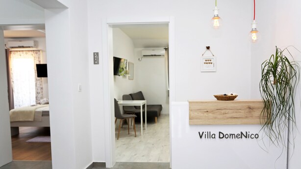 A modern interior with a reception desk, a dining area, and a living space. - Guesthouse Villa DomeNico (Lozovac)