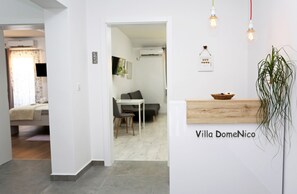 Een modern interieur met een receptiebalie, een eetgedeelte en een zithoek.