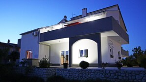 A modern two-story house with a stone facade, large windows, and a flat roof. - Guesthouse Villa DomeNico (Lozovac)