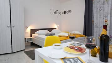 A neatly arranged bedroom with a bed, bedside table, and a wall with a motivational quote.