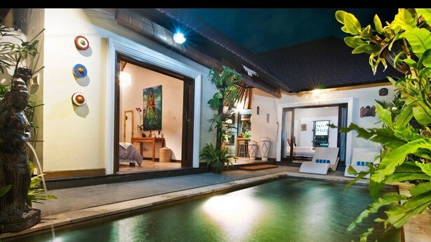 A modern house with a swimming pool, a dining area, and a living room with a painting.