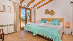Une chambre avec deux lits, un balcon et une vue sur l’extérieur.