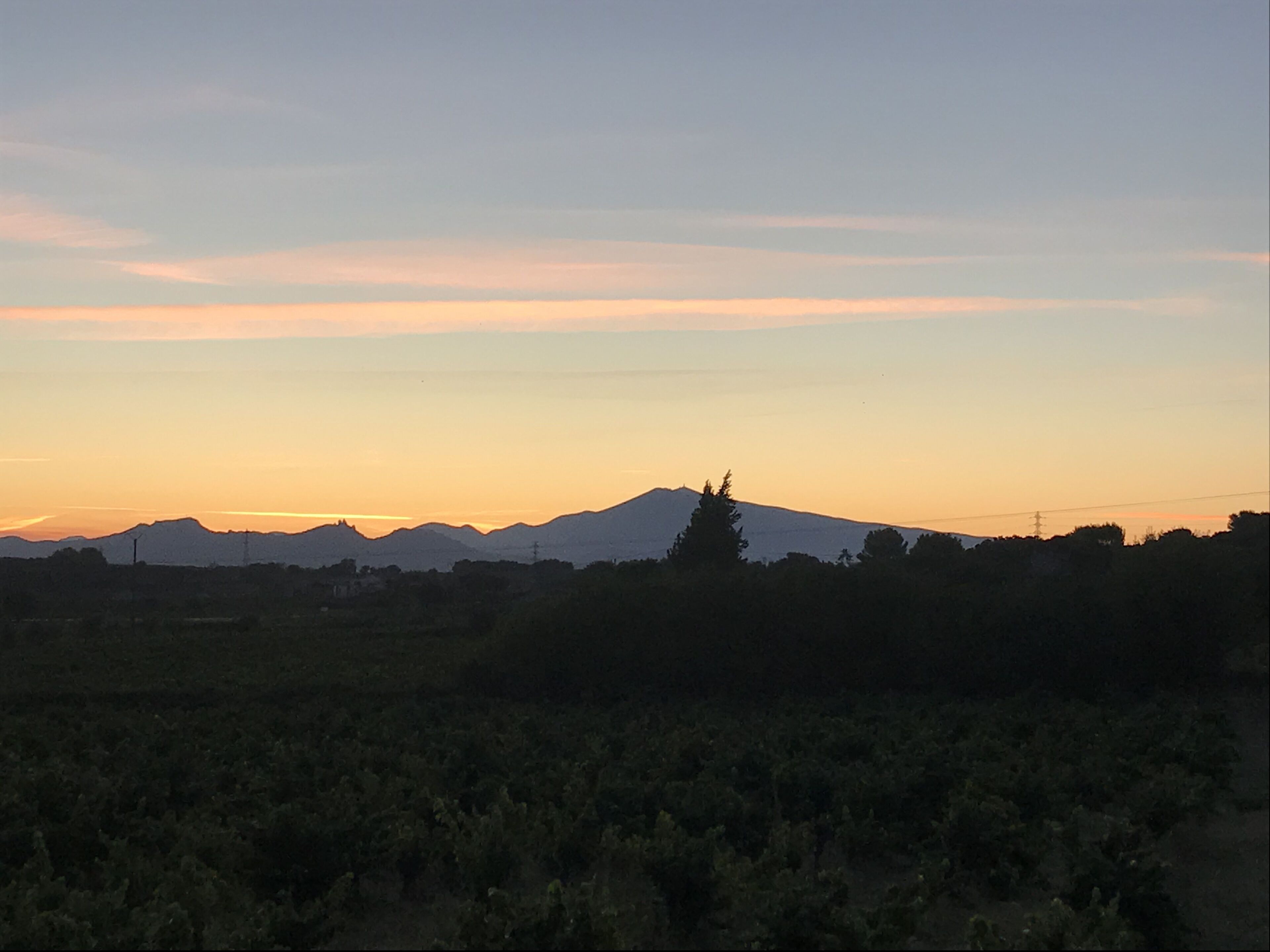 A mountain range silhouette against a sunset sky.