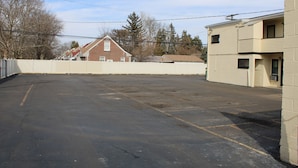An empty parking lot with a building in the background. - Royal Budget Inn (Redford)