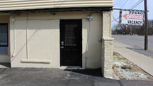 A building with a black door and a sign indicating an office vacancy. - Royal Budget Inn (Redford)