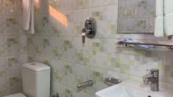 Ein Badezimmer mit Toilette, Waschbecken und Handtuchhalter.