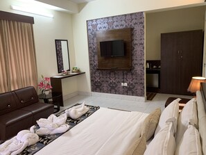 Deluxe Suite | Living room | 39-inch LED TV with satellite channels, TV