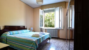 A bedroom with a bed, a window, a radiator, and a chair. - Residence Parco Ducale (Parma)
