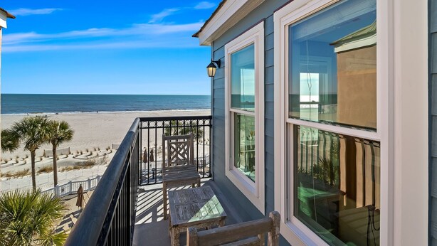 Une propriété située en bord de mer, dotée d’un balcon avec vue sur l’océan.