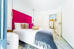 A modern hotel room with a large bed, a bright pink accent wall, and a basket on the bed. - Casa Toro Luxury Town House with Rooftop Garden Sea View (Calp)