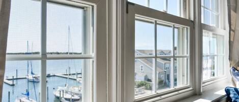 A room with large windows overlooking a marina.