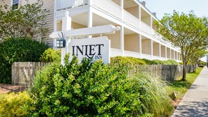 A hotel with a sign reading "INLET INN" in front of a building with multiple balconies and a white exterior. - Inlet Inn NC (Beaufort)