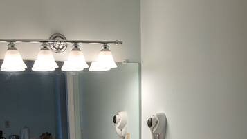 A bathroom with a sink, mirror, and hairdryer.