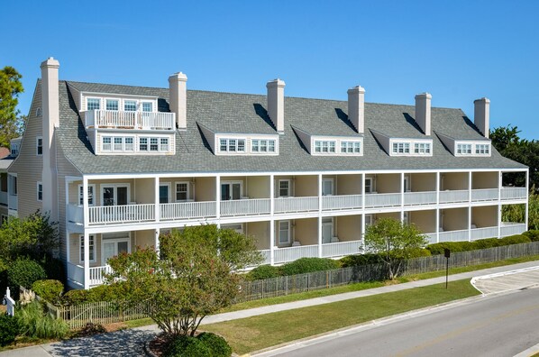A multi-story building with a symmetrical facade, multiple balconies, and a central chimney.