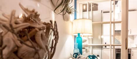 Una zona de cocina con una encimera blanca, una lámpara azul y un cuenco con adornos.