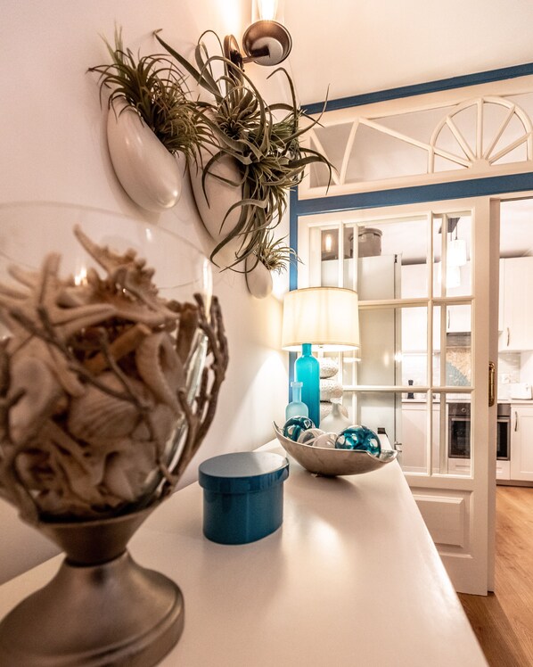 A kitchen area with a white countertop, a blue lamp, and a bowl of decorative items. - Luxury home, centrally located with a beautiful balcony overlooking the marina. (Ponta Delgada)