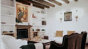 A living room with a fireplace, white sofas, a coffee table, and a bookshelf with various items. - Country home in Dosbarrios, Toledo (Dosbarrios)