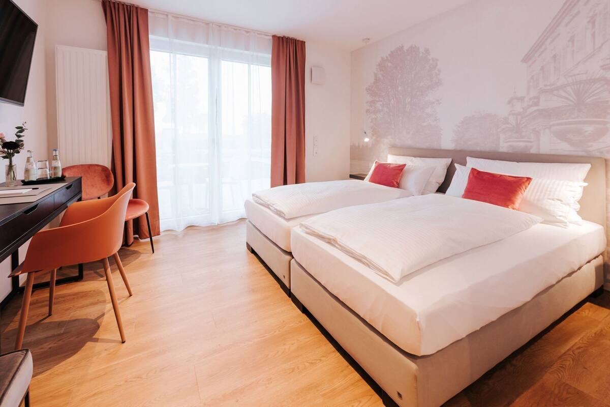 A hotel room with a bed, a desk, and a chair.