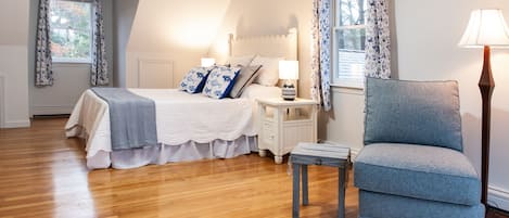 A bedroom with a bed, bedside tables, a chair, and a lamp.