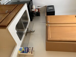 Enjoy cooking in this well-equipped kitchen with a stainless steel sink, coffee machine, and ample storage.