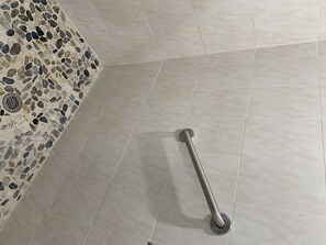 Features a mosaic wall and a grab bar for added support.