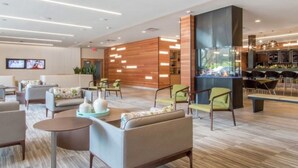 Een moderne lobby met zithoeken, een receptiebalie en een bar.